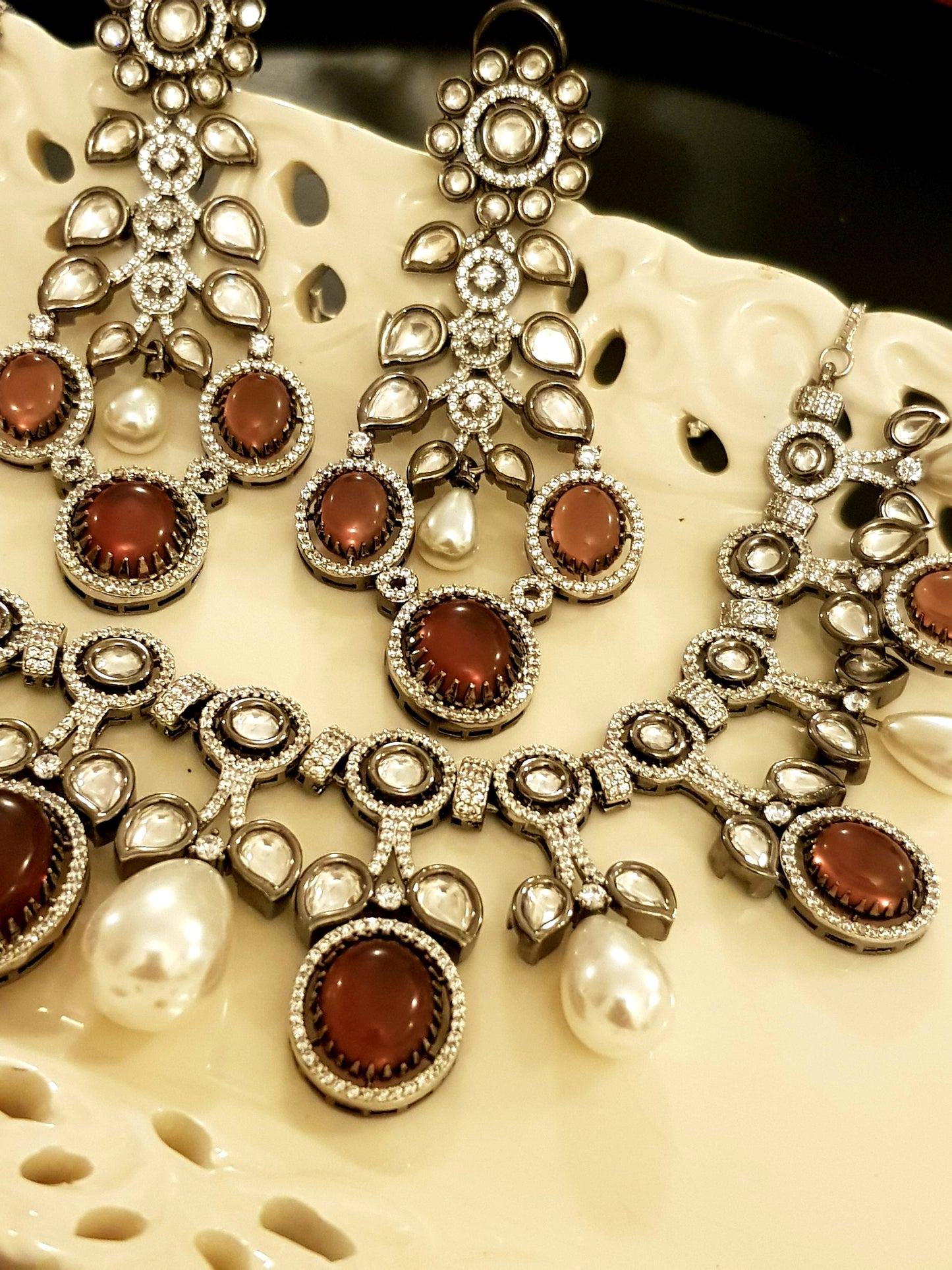 Platinum finish set with plum coloured stone, kundan, pearl and CZ necklace, matching earrings