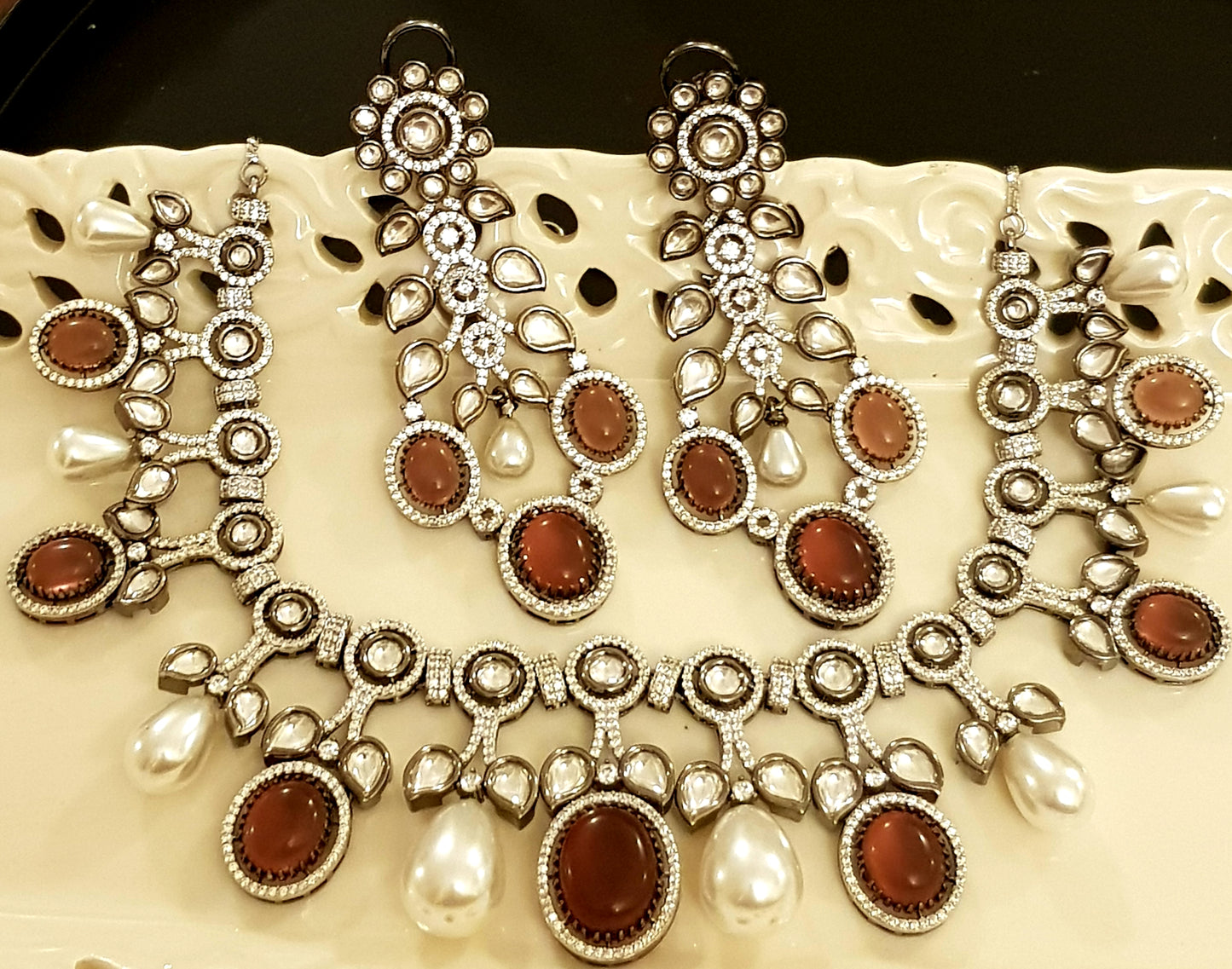 Platinum finish set with plum coloured stone, kundan, pearl and CZ necklace, matching earrings