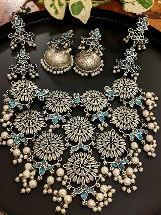 Antique silver finish set, silver flowers big pendant necklace with blue stone and pearl detailing, matching jhumkis (earrings)