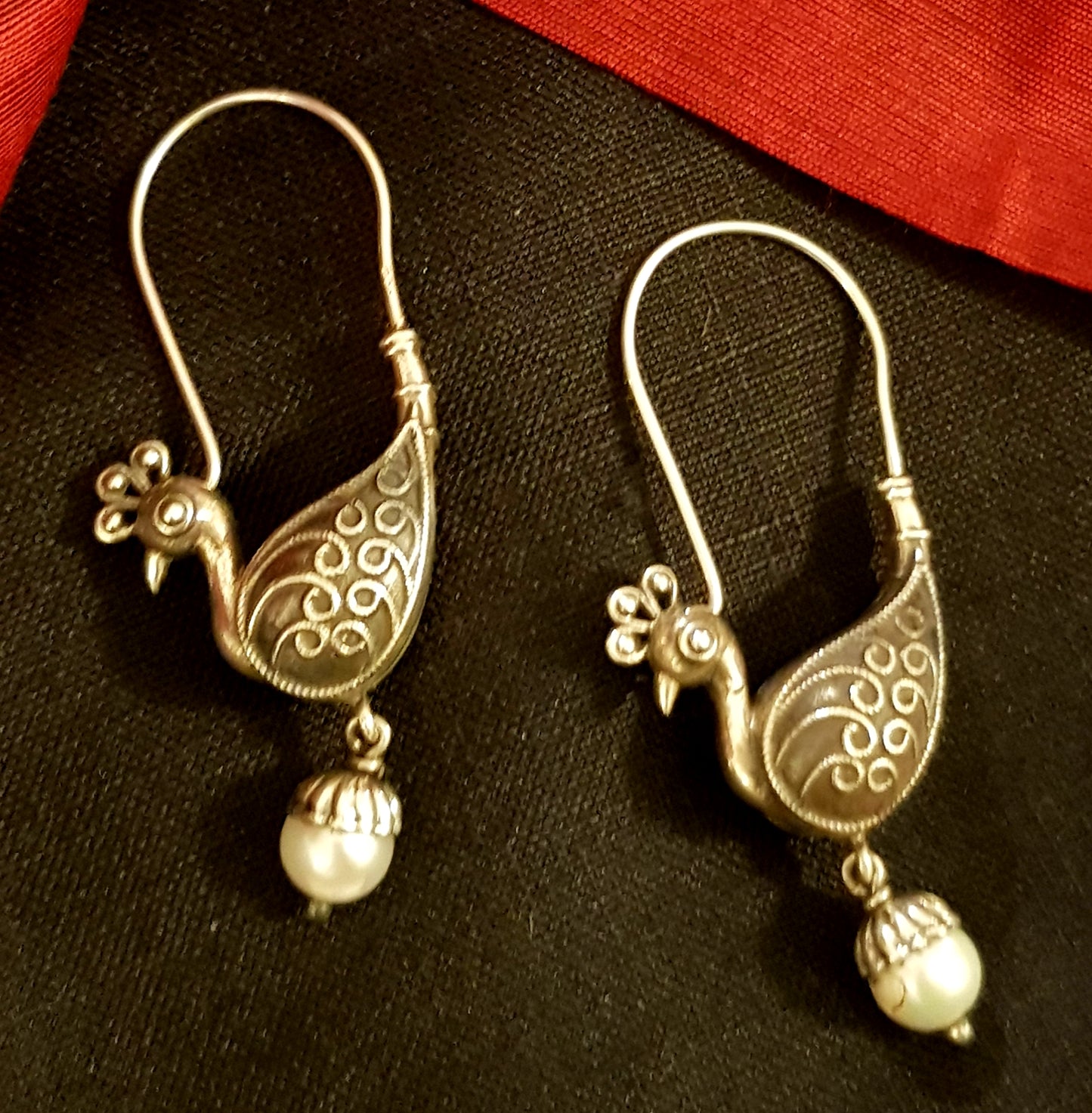 Silver hoop earrings with peacock motif and hanging pearl drops