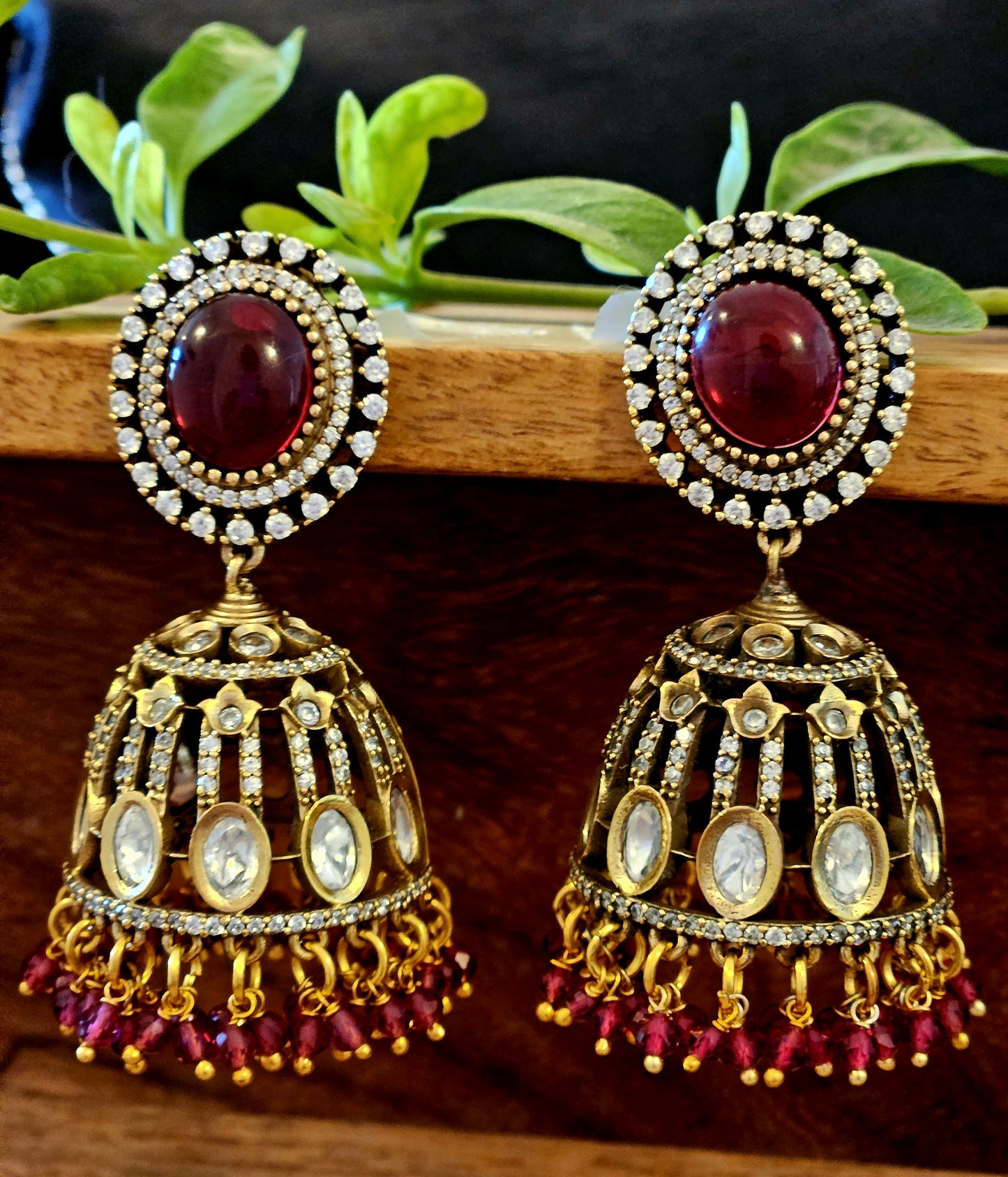 Antique gold finish kundan Jhumka (earrings), oval ruby/emerald stone stud with kundan and clear stone detailing on dome