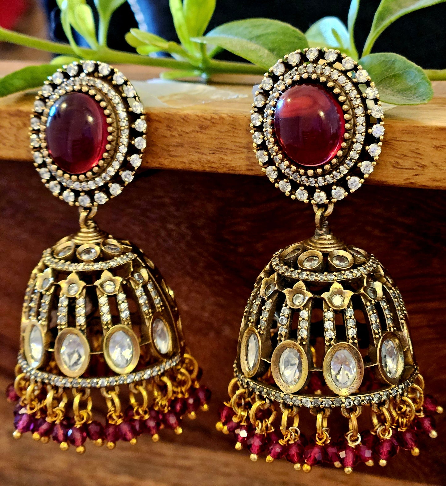 Antique gold finish kundan Jhumka (earrings), oval ruby/emerald stone stud with kundan and clear stone detailing on dome