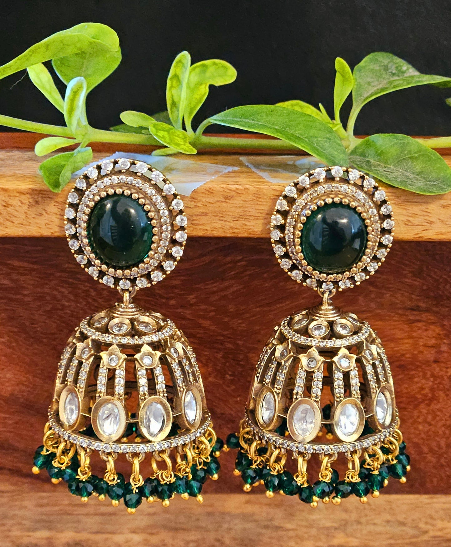 Antique gold finish kundan Jhumka (earrings), oval ruby/emerald stone stud with kundan and clear stone detailing on dome