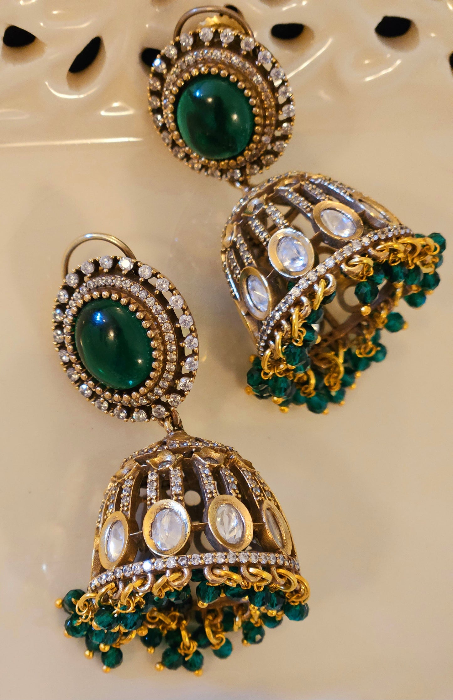 Antique gold finish kundan Jhumka (earrings), oval ruby/emerald stone stud with kundan and clear stone detailing on dome