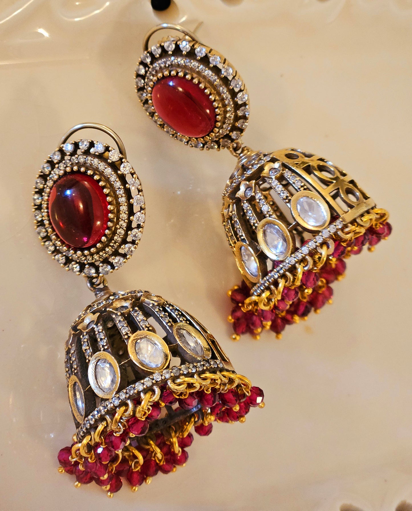 Antique gold finish kundan Jhumka (earrings), oval ruby/emerald stone stud with kundan and clear stone detailing on dome