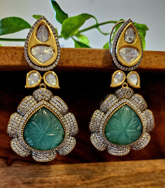 Gold finish danglers (earrings), big teardrop shaped flower with pale green/dark green stone in the center hanging under matching stud