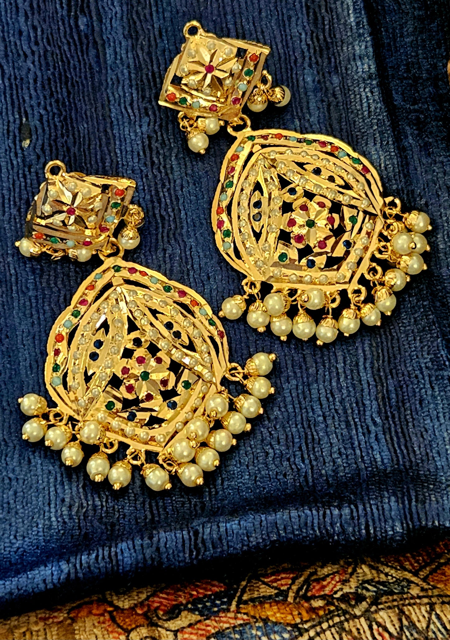 Gold finish jadau earrings with navratan stone inlay and pearl finishing