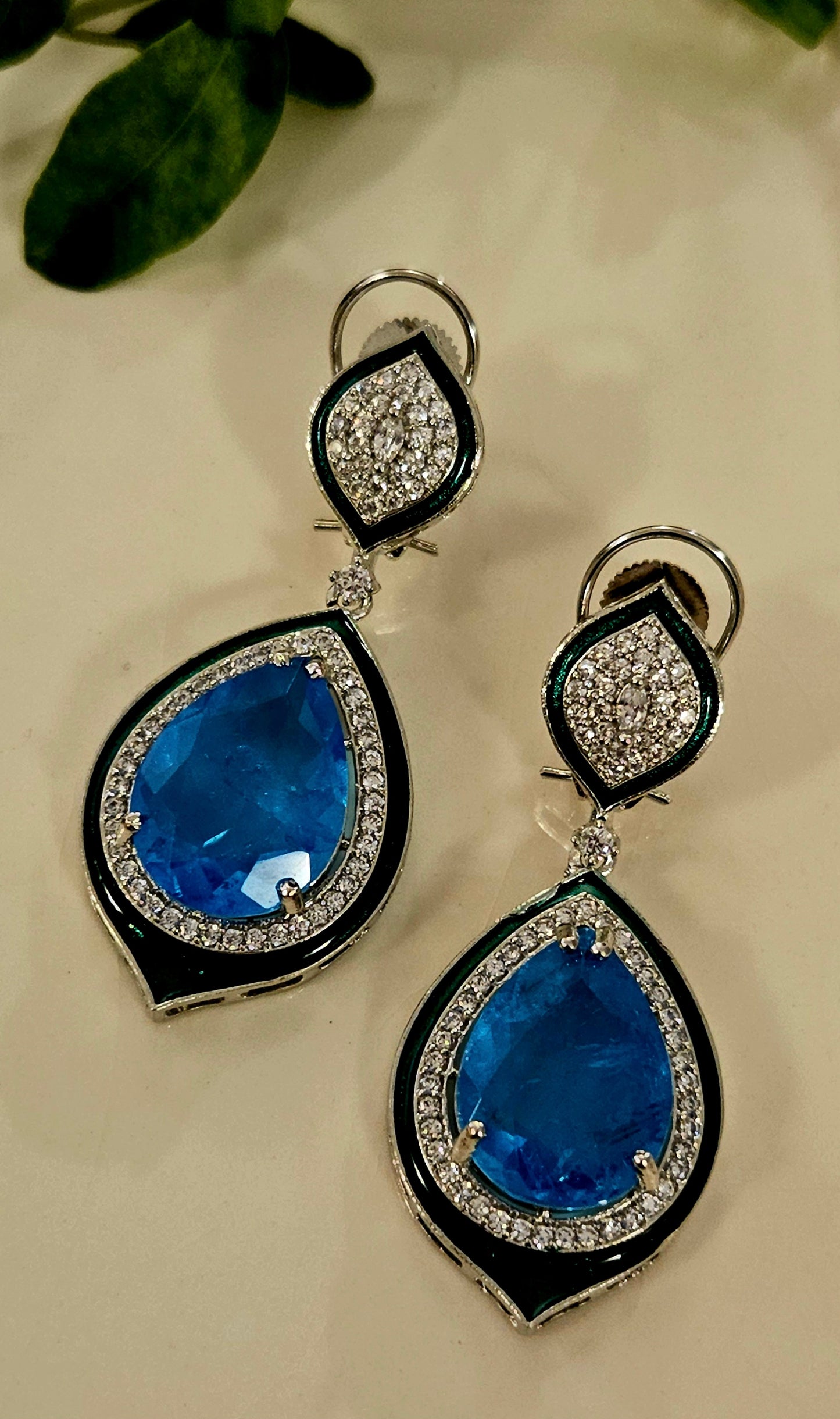 Platinum finish earrings with big teardrop shaped blue stone outlined with CZ and green meenakaari