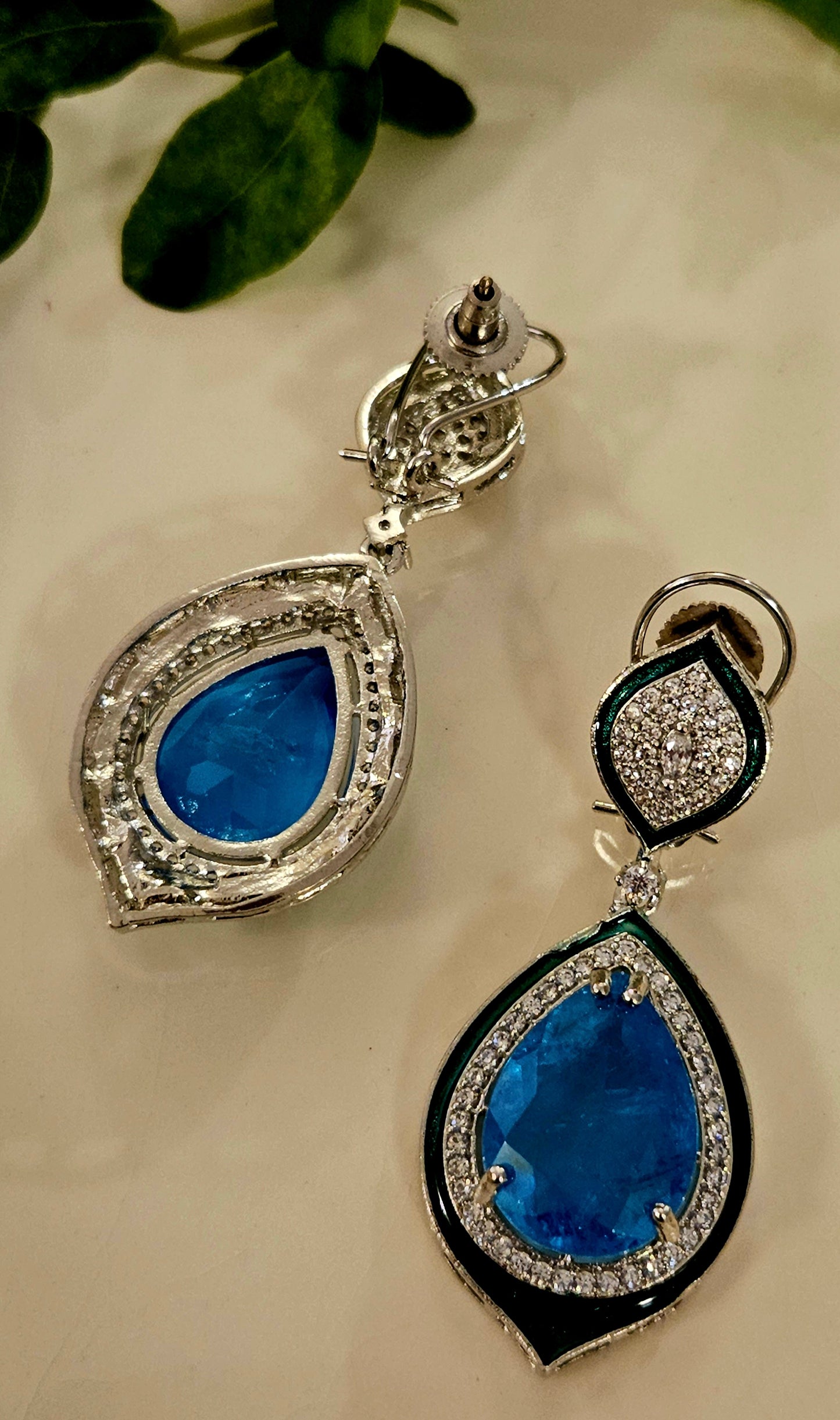 Platinum finish earrings with big teardrop shaped blue stone outlined with CZ and green meenakaari