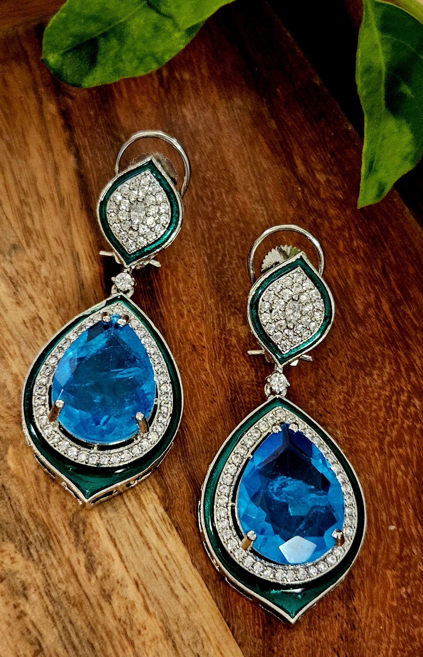 Platinum finish earrings with big teardrop shaped blue stone outlined with CZ and green meenakaari