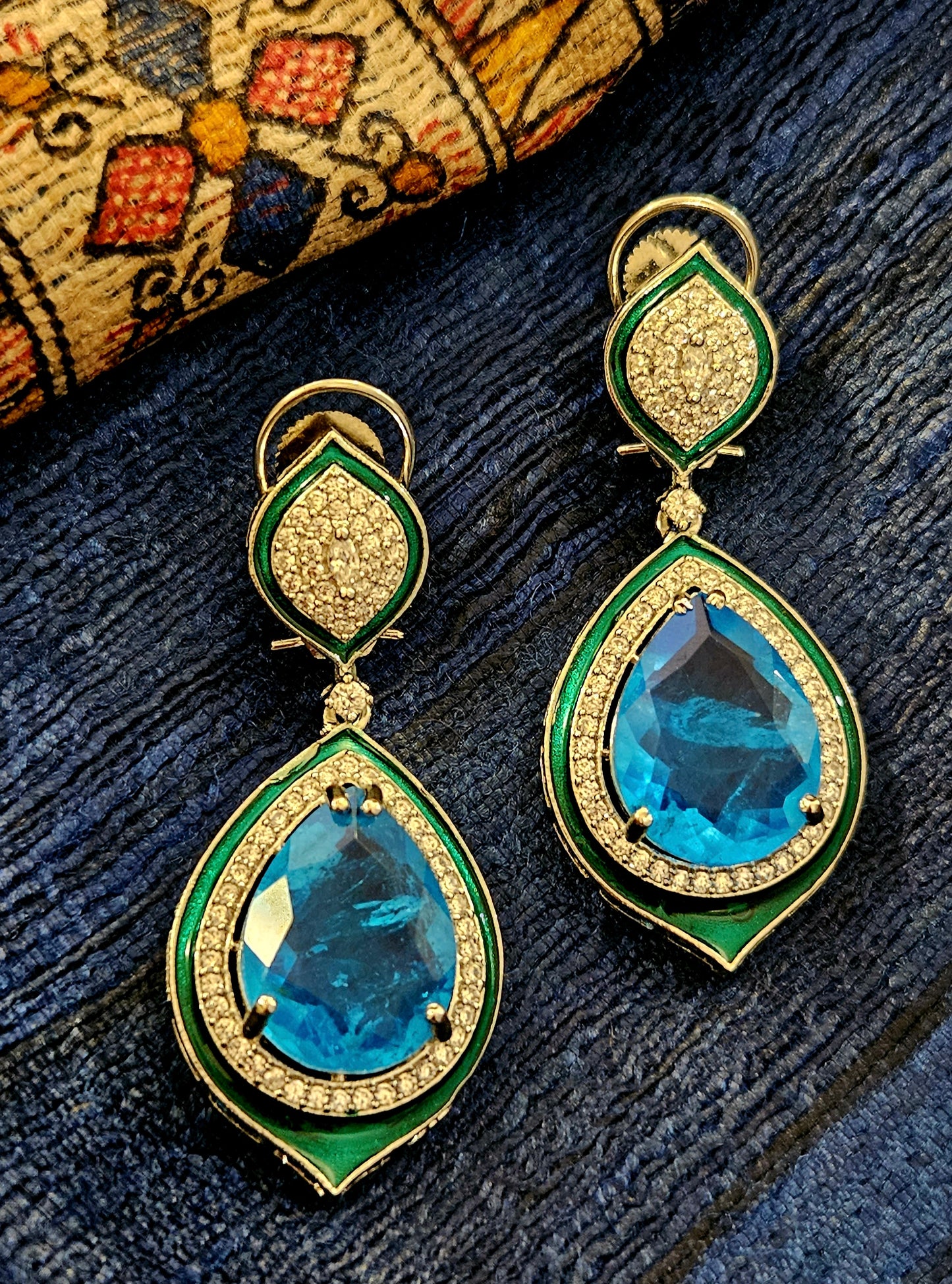 Platinum finish earrings with big teardrop shaped blue stone outlined with CZ and green meenakaari