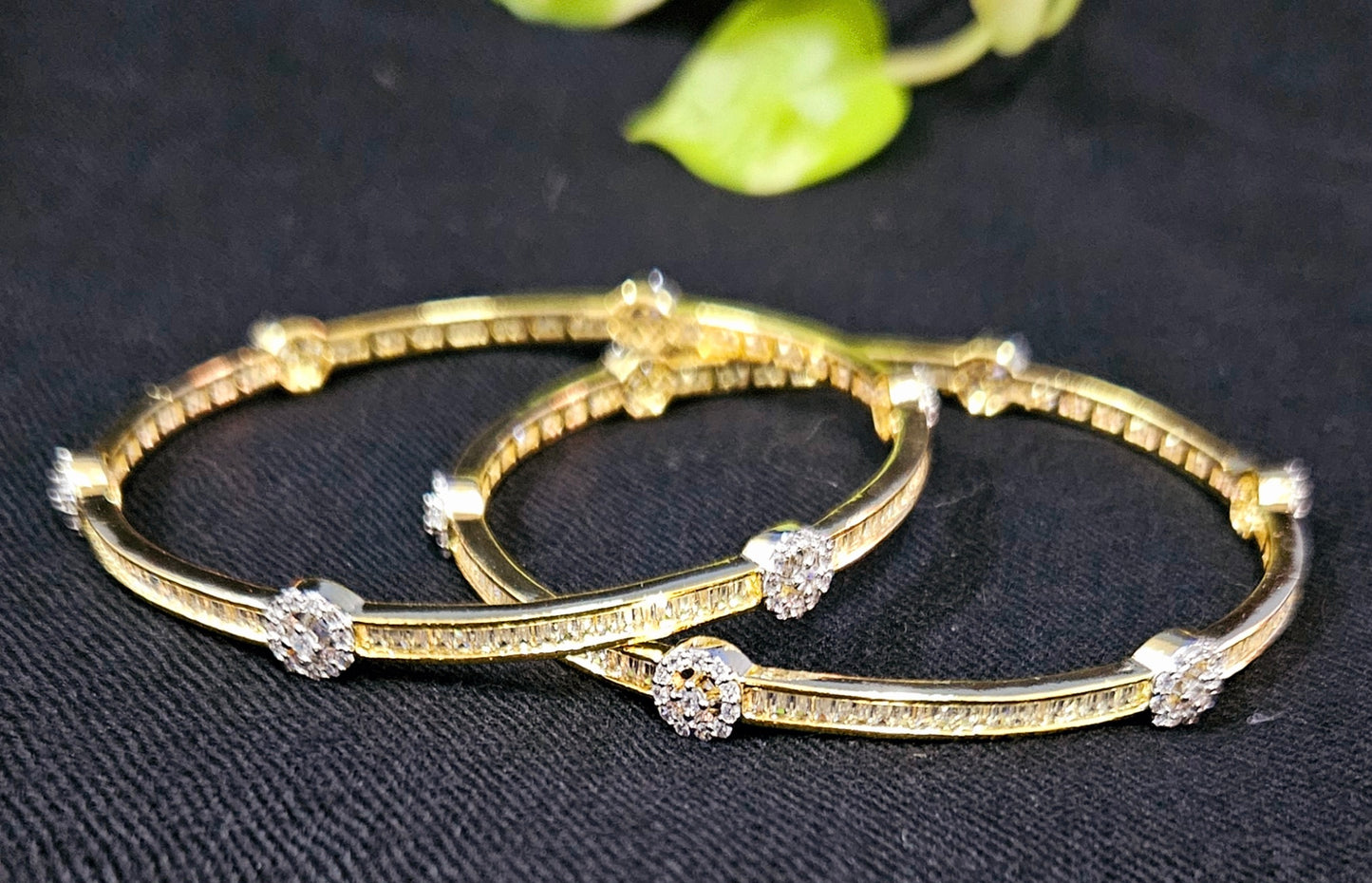 Gold finish sleek bangles with small cylindrical crystal and CZ flower design (2 pcs)