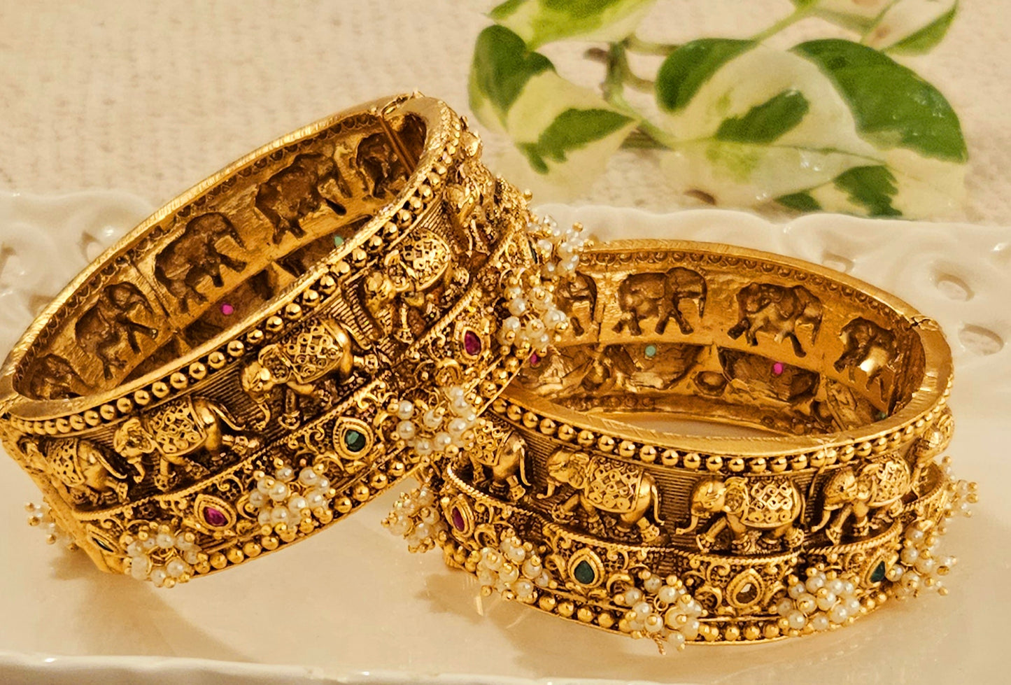 Gold finish broad kara (bangle) with marching elephants and pearl bead cluster (2 pcs)