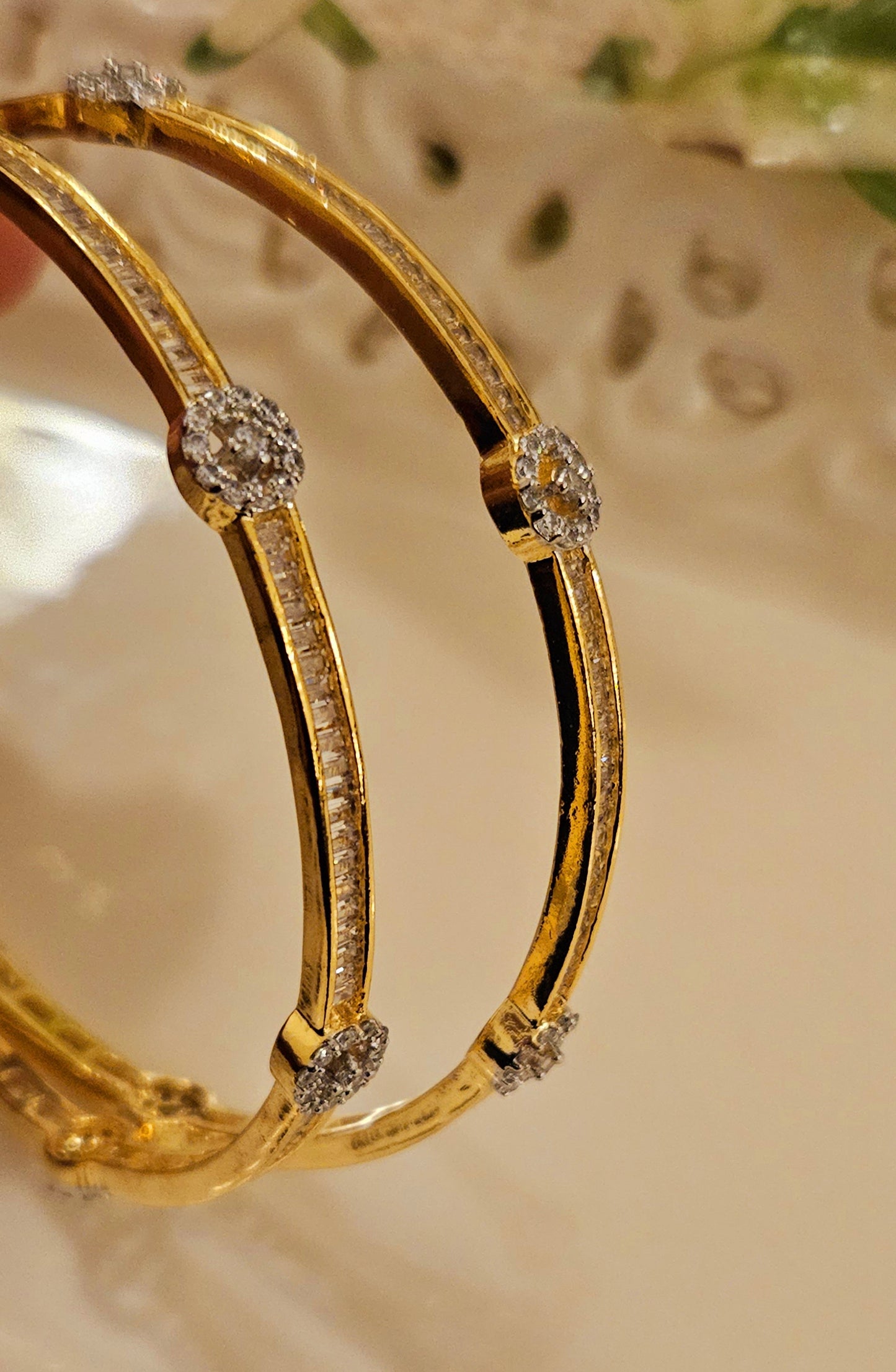 Gold finish sleek bangles with small cylindrical crystal and CZ flower design (2 pcs)