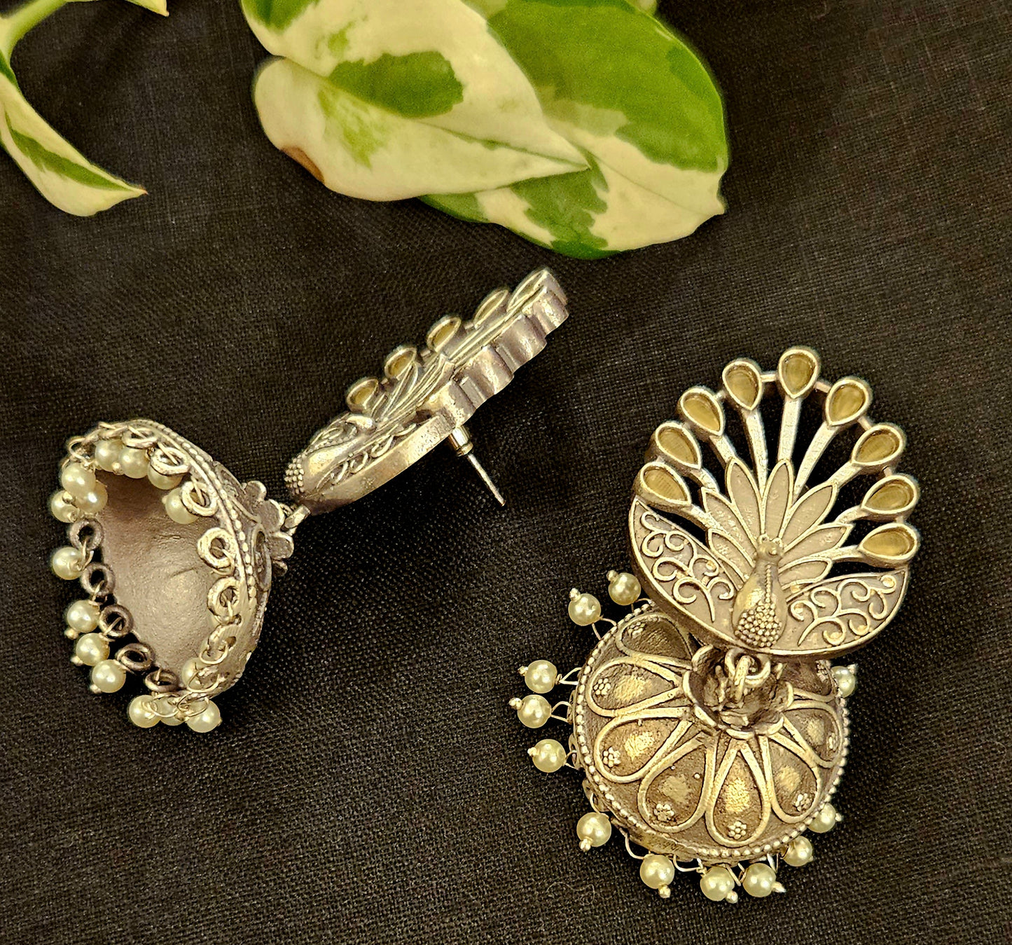 Silver finish jhumka (earrings) with peacock design stud and flat dome