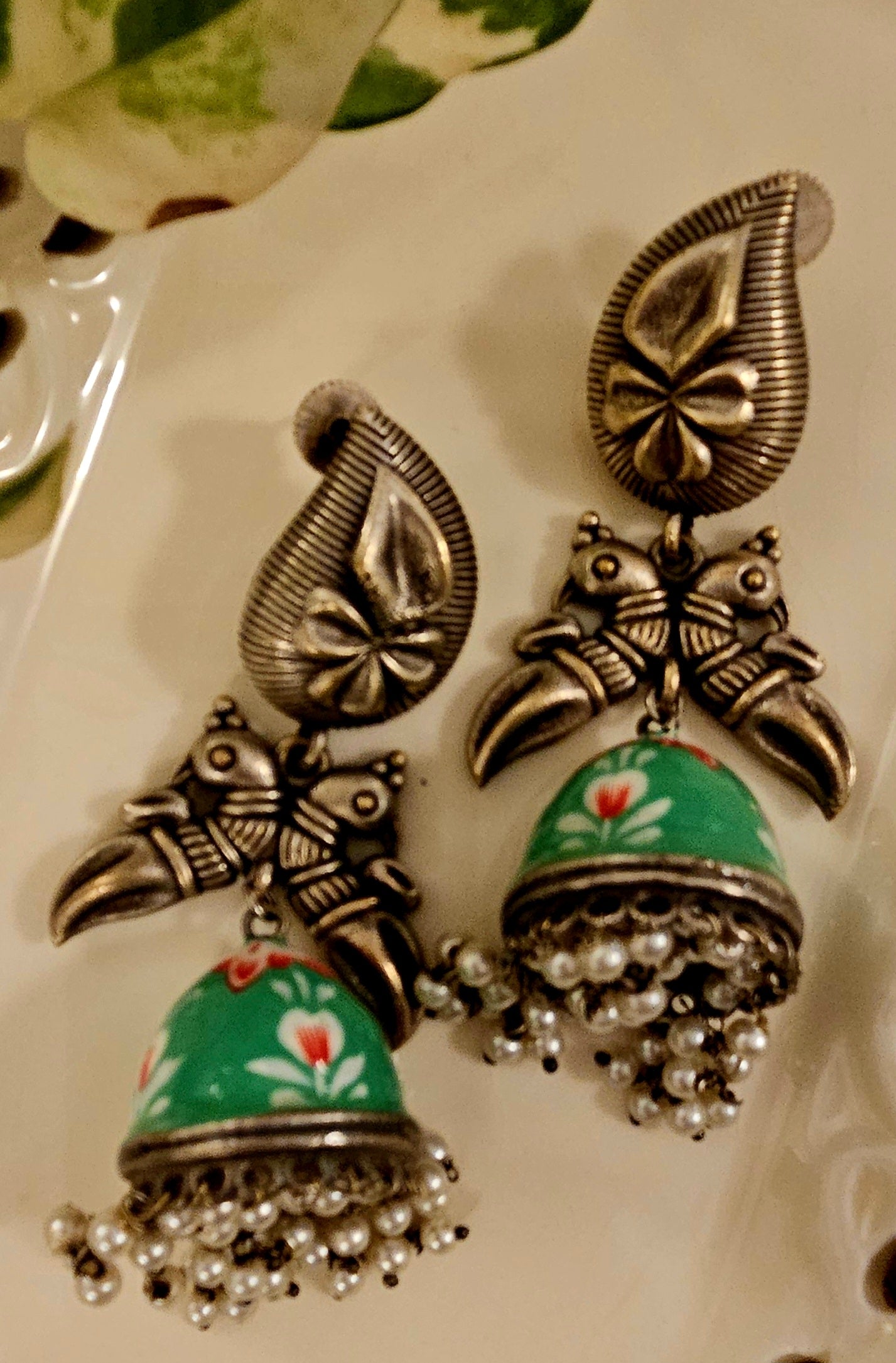 Silver finish hand painted jhumka (earrings) with paisley stud and parrot motif