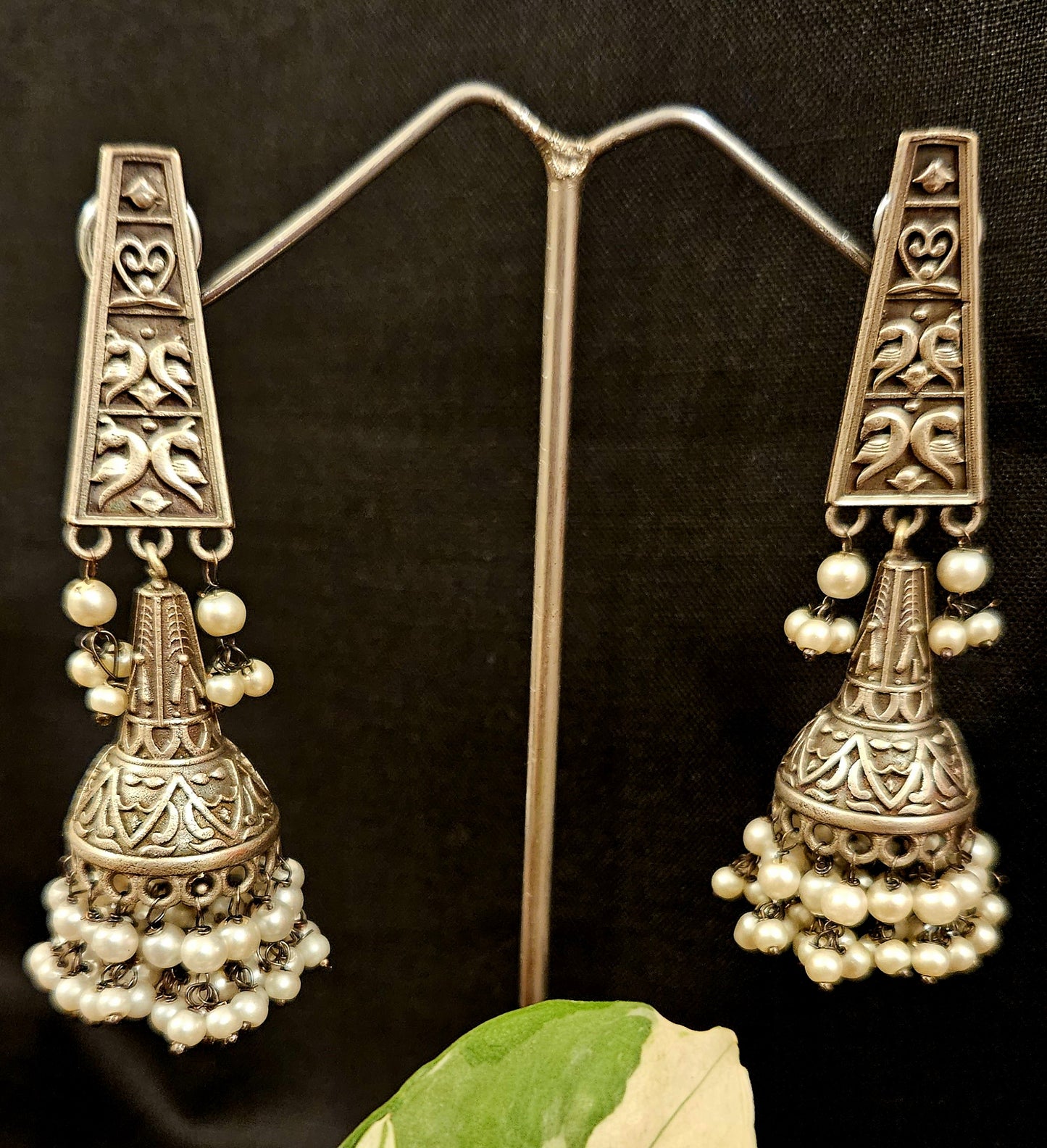 Silver finish jhumka (earrings) with intricate carving and pearls