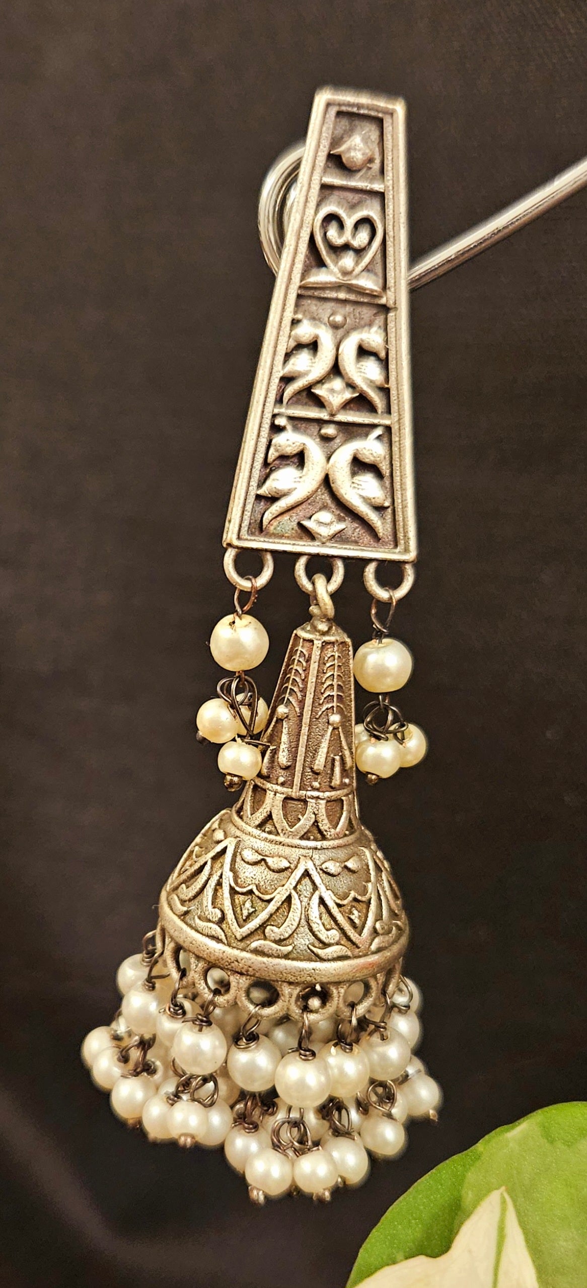 Silver finish jhumka (earrings) with intricate carving and pearls