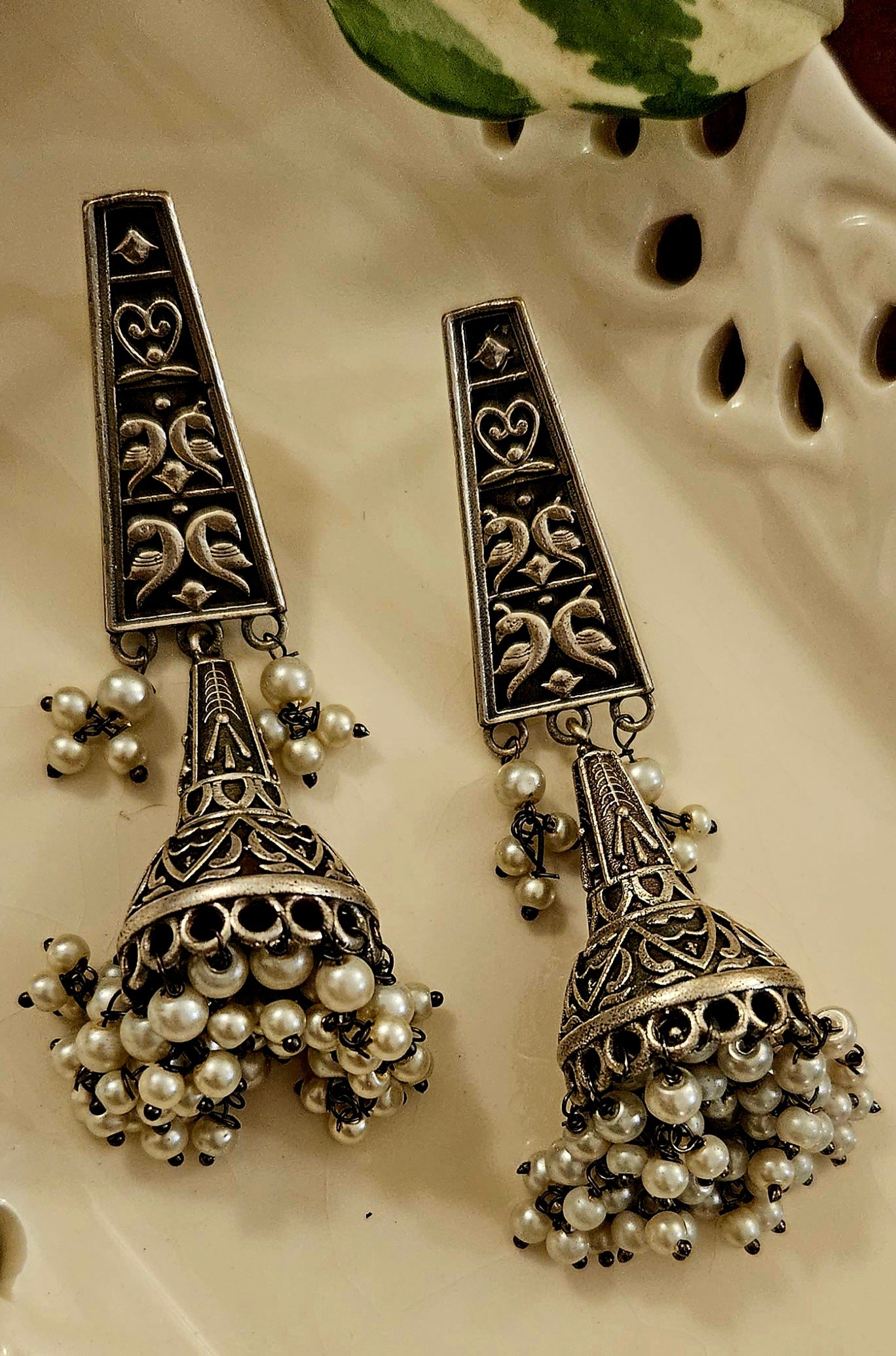 Silver finish jhumka (earrings) with intricate carving and pearls