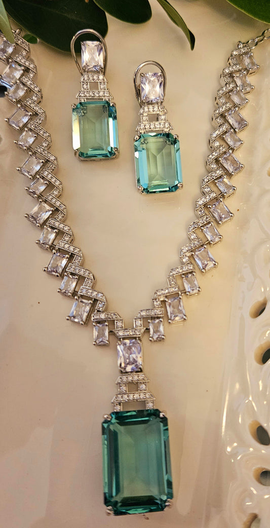 Platinum finish set with pale pink/mint green pendant on zig-zag pattern neutral colour CZ necklace, matching earrings