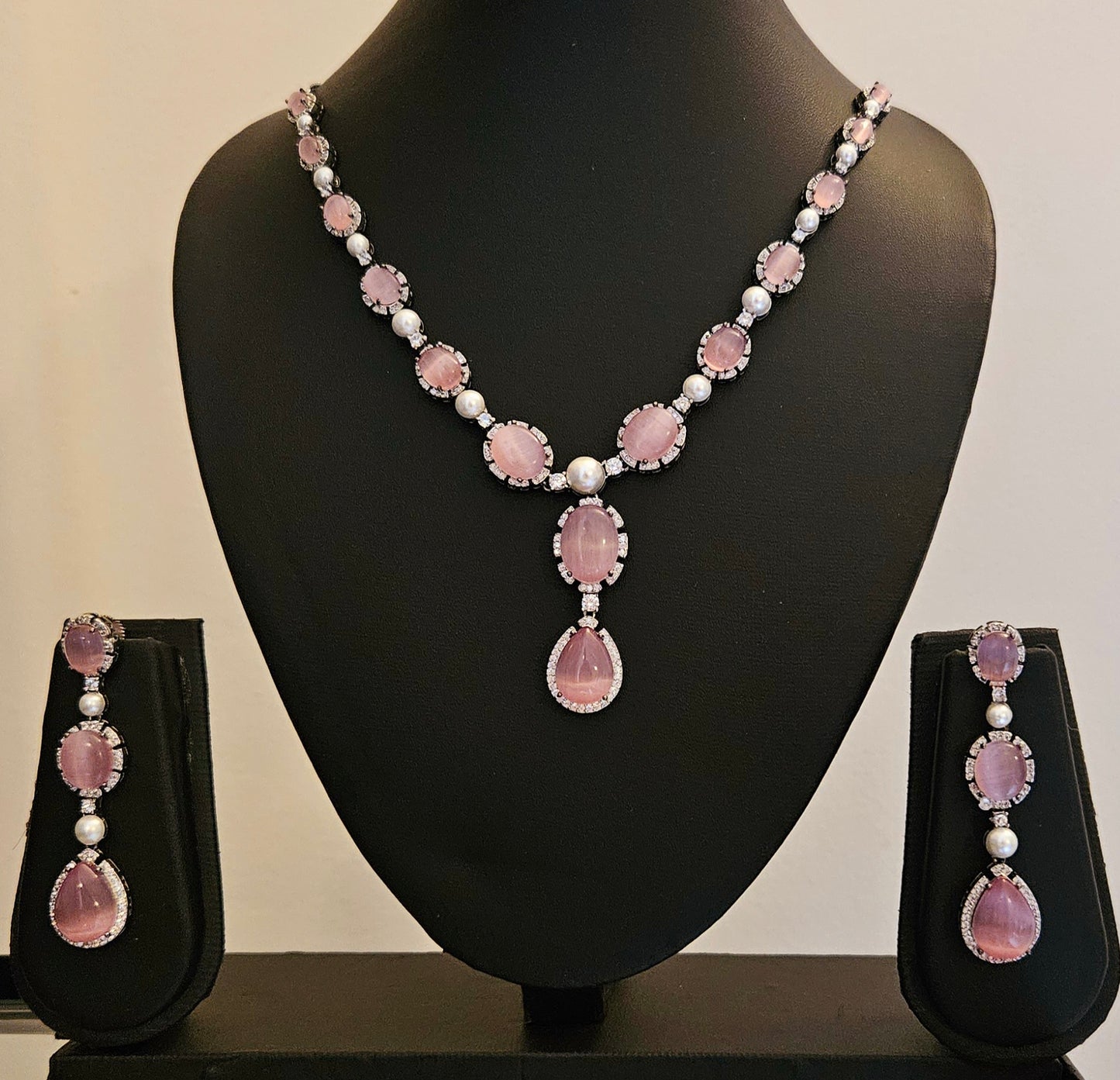 Platinum finish set with teardrop sapphire/pink stone set with pearl and CZ, matching earrings