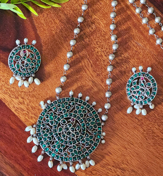 Silver finish long necklace set with big round pendant embellished with green/red stones, matching studs (earrings)