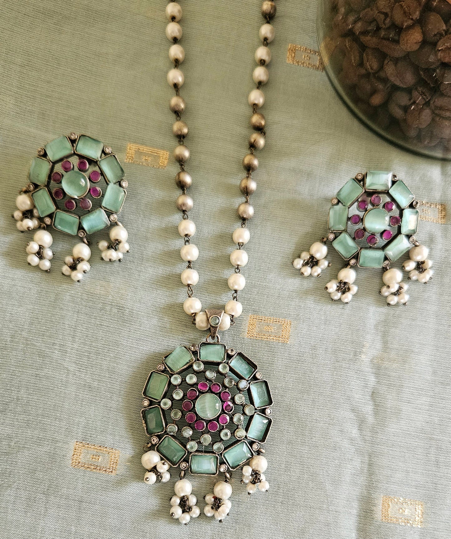 Silver finish long necklace set with big round pendant embellished with peach/green stones, matching studs (earrings)