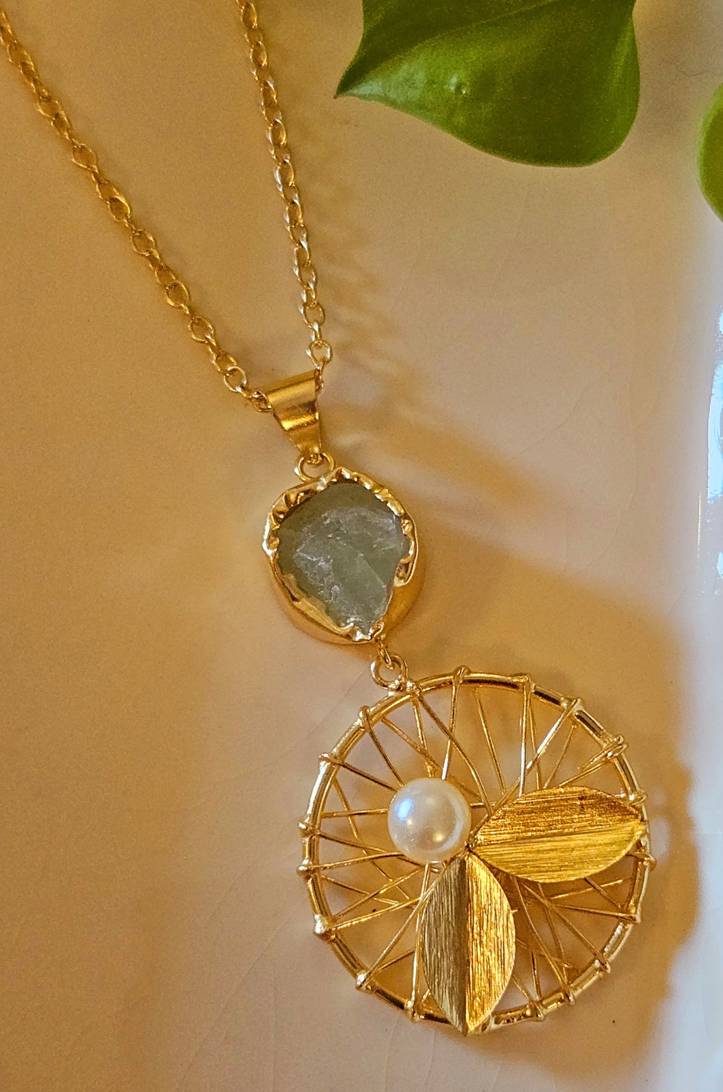 Gold finish necklace with round pendant wire work, golden petal and pearl under mint green stone,