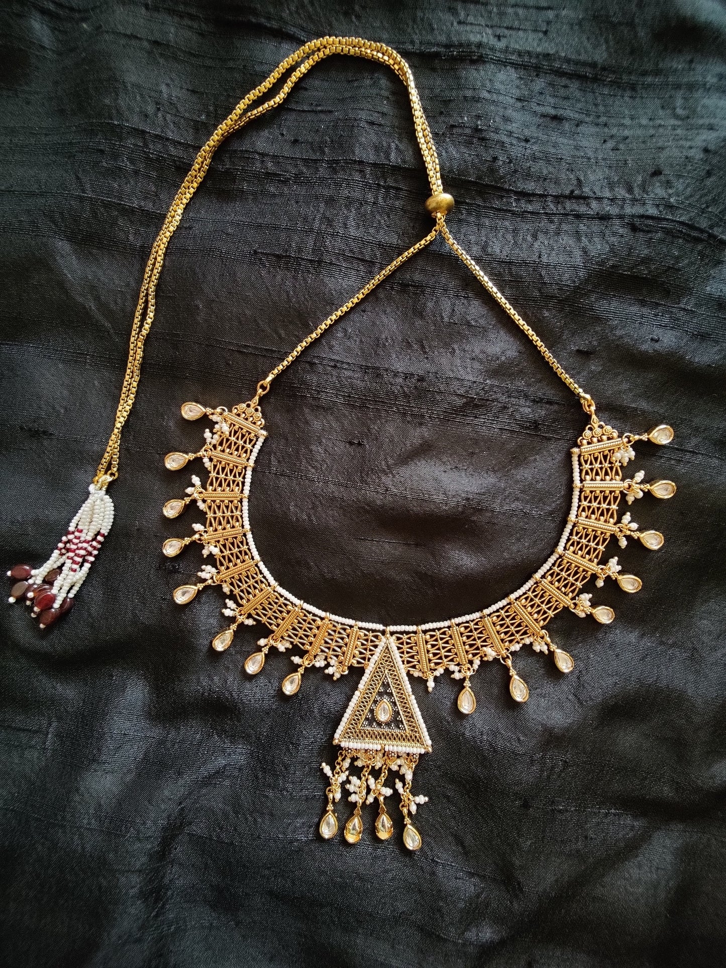 Intricate gold finish necklace and dangling earrings with black enamel, kundan and delicate miniature pearls