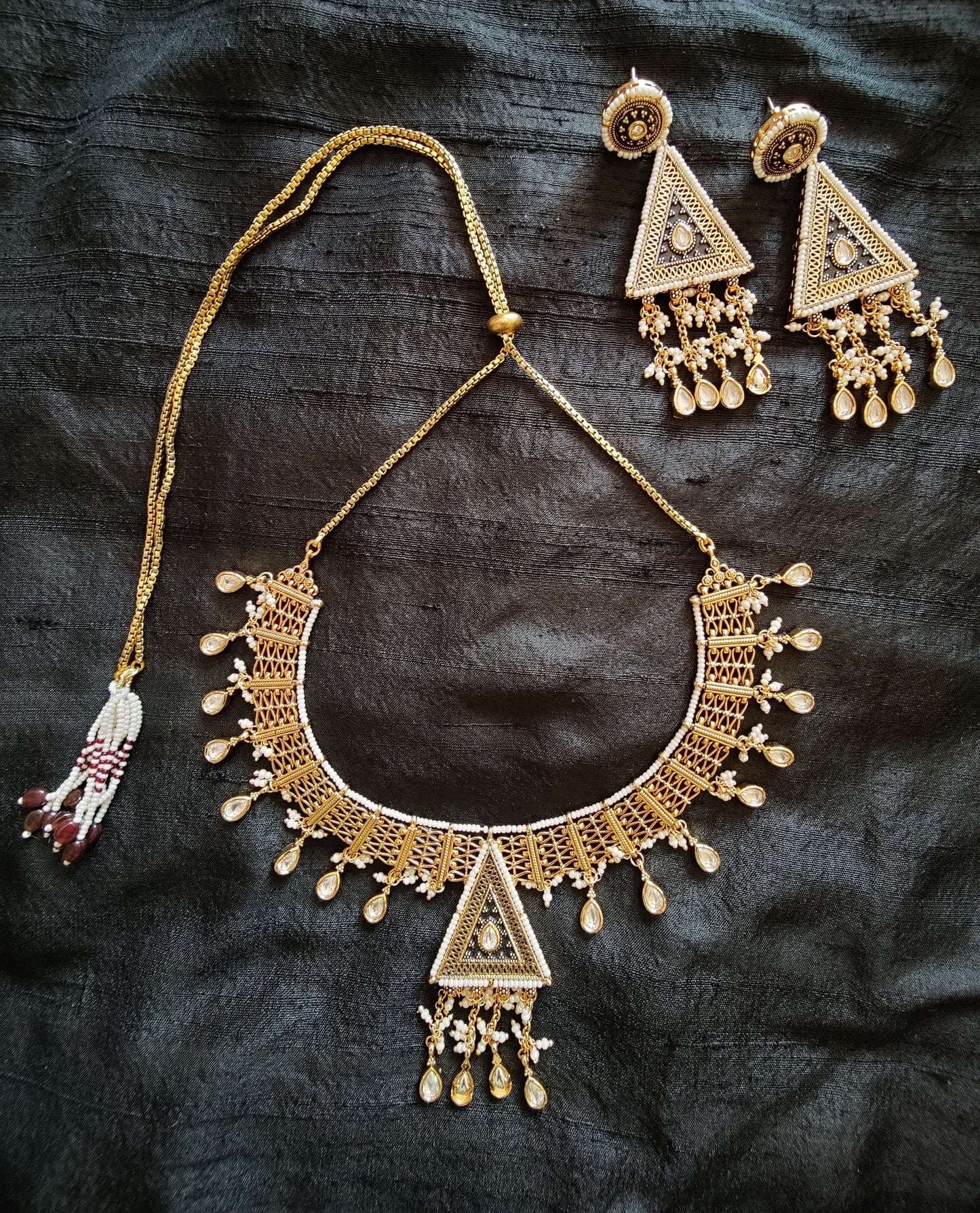 Intricate gold finish necklace and dangling earrings with black enamel, kundan and delicate miniature pearls