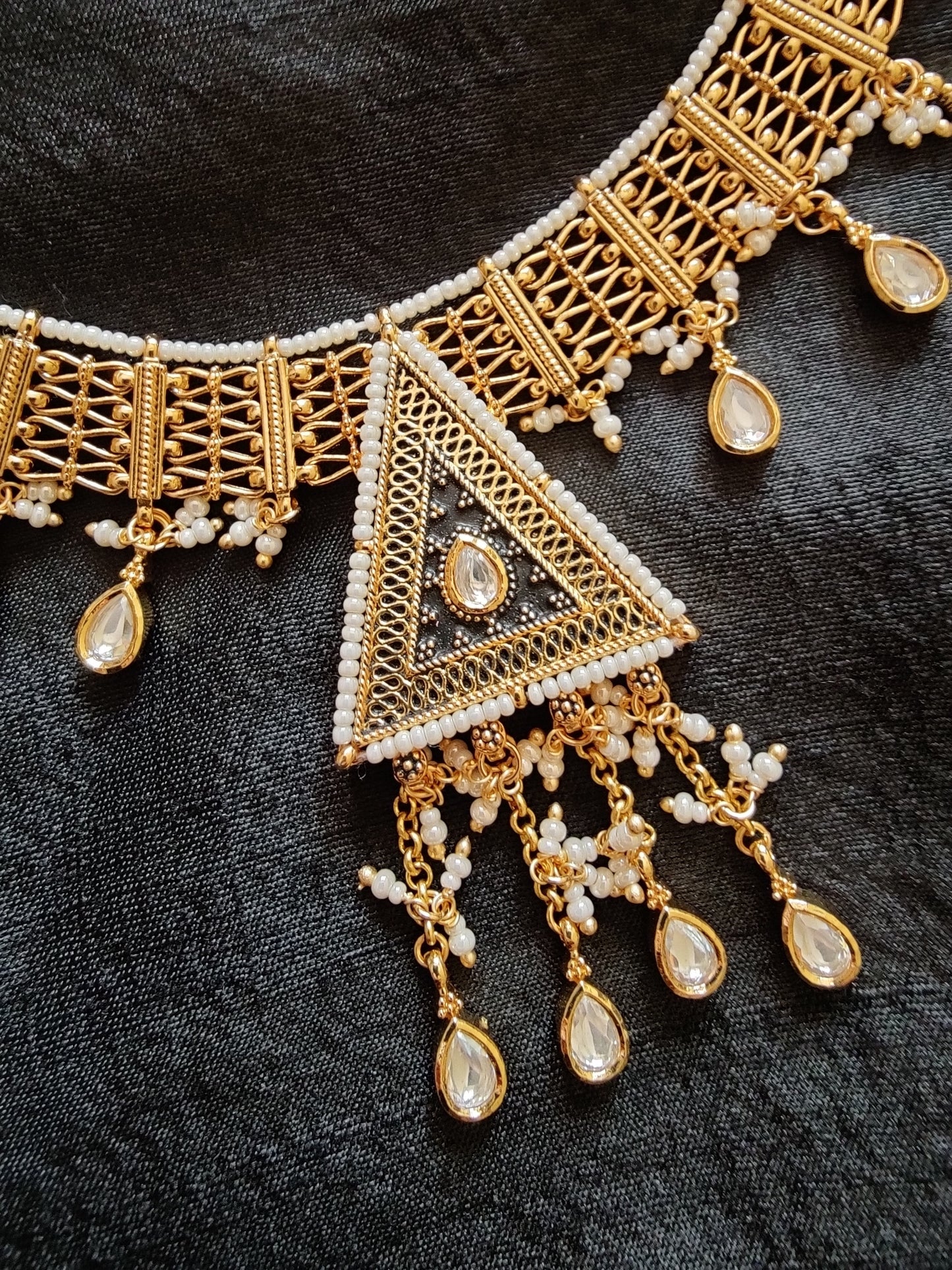 Intricate gold finish necklace and dangling earrings with black enamel, kundan and delicate miniature pearls