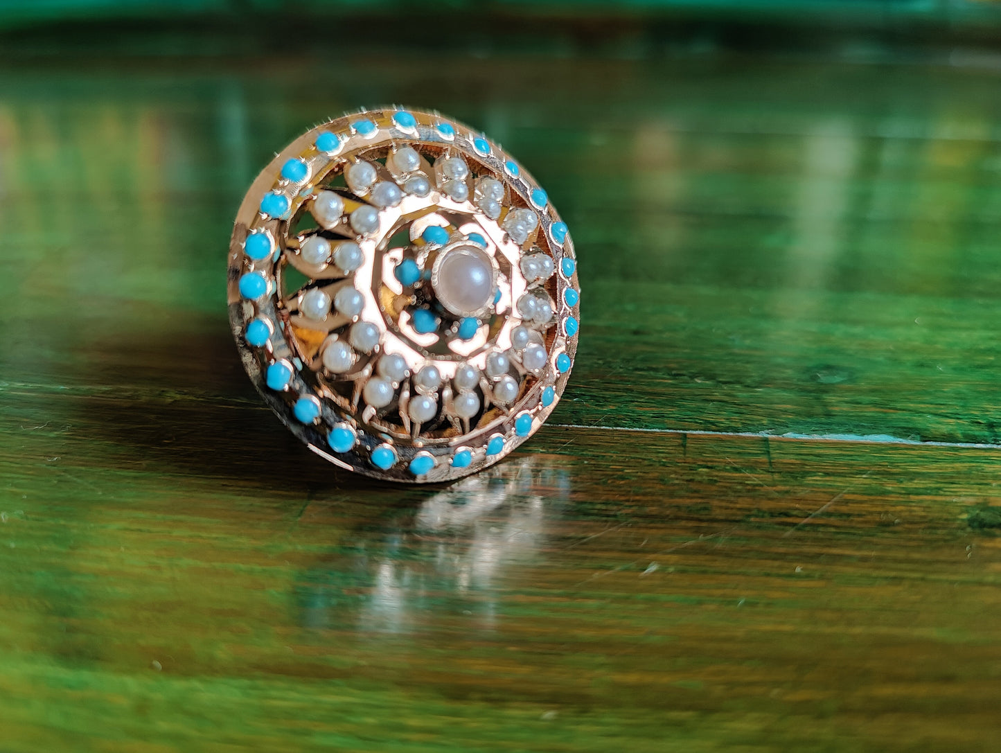 Gold finish circular jadau ring with blue/turquoise stone and pearl detailing