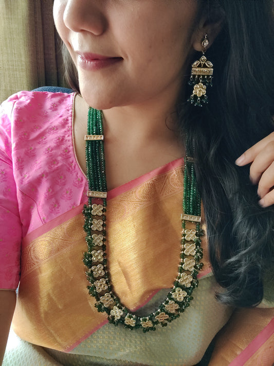 'Green goddess' gold finish necklace with square kundan tikdas held in delicate emerald strands, with matching earrings